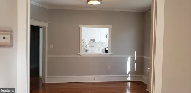 an empty room with wooden floor and a window