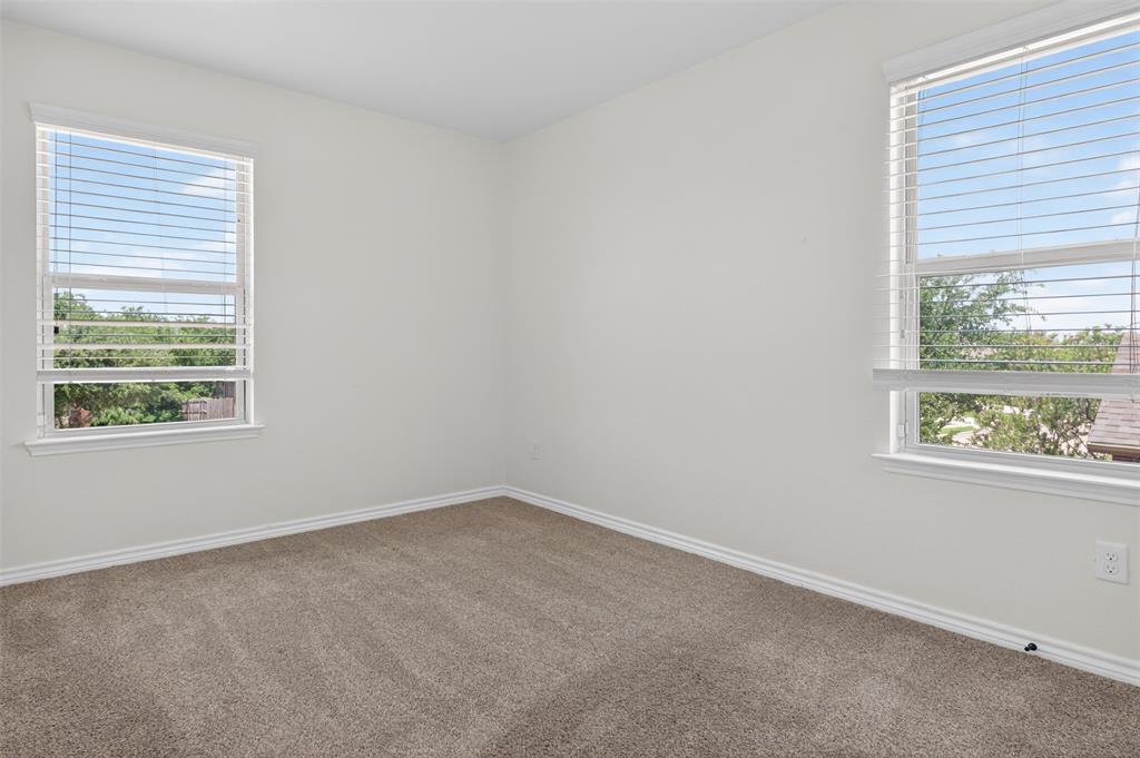 8728 Maple Ridge Trail Fort Worth, TX 76244 - Photo 32 of 40 Neutral tone wall paint, two windows with horizontal blinds, carpet flooring, and white trim molding