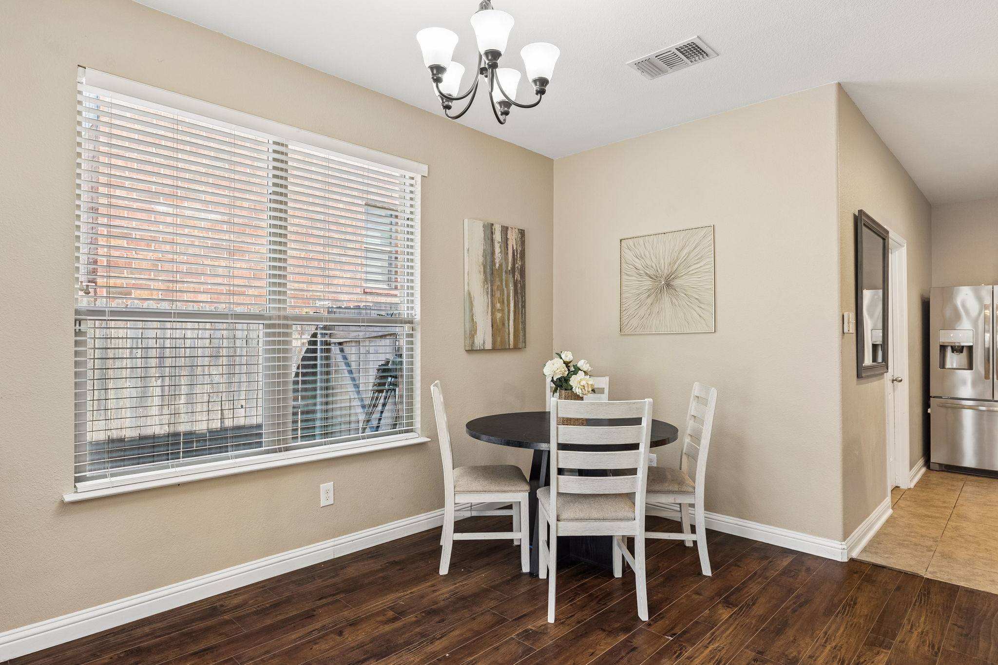 1113 Yellow Iris Road Leander, TX 78641 - Photo 7 of 26 Rich wood floors and a large window define this welcoming dining space.