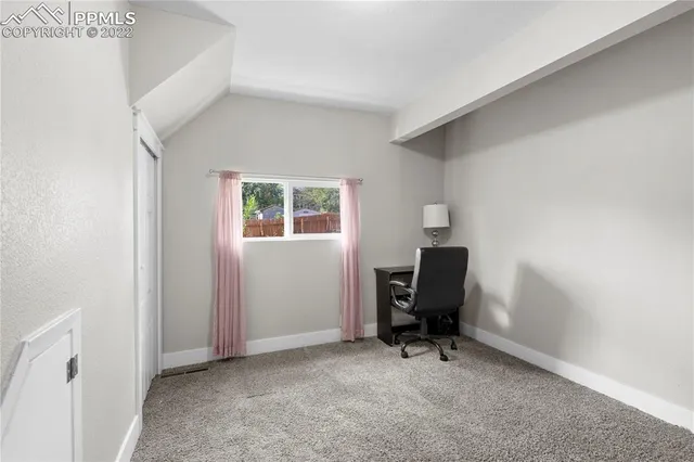 a view of a workspace with furniture and a window