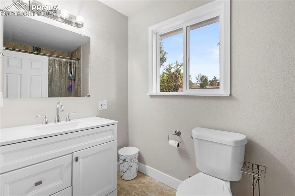 738 Harrison Place Colorado Springs, CO 80905 - Photo 13 of 25 a bathroom with a toilet sink and mirror