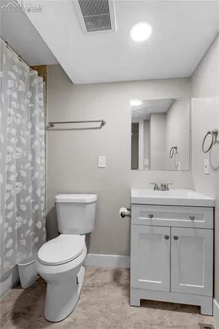 a bathroom with a granite countertop toilet sink and mirror