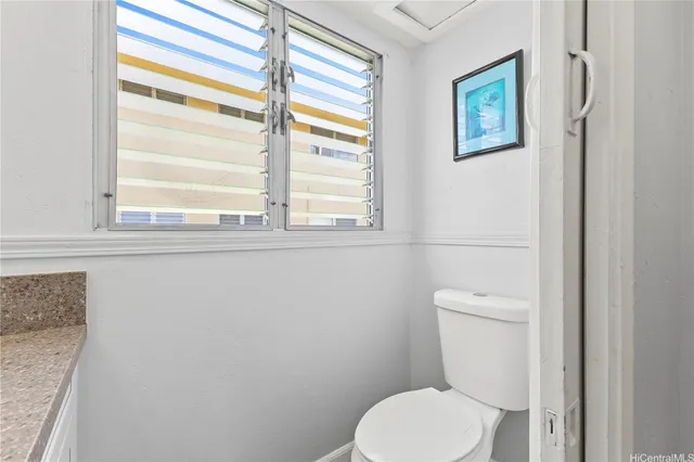 a white toilet sitting next to a window
