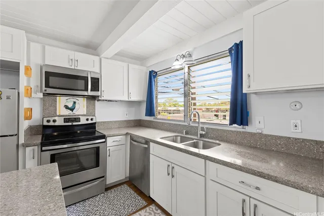 a kitchen with granite countertop a sink and steel appliances