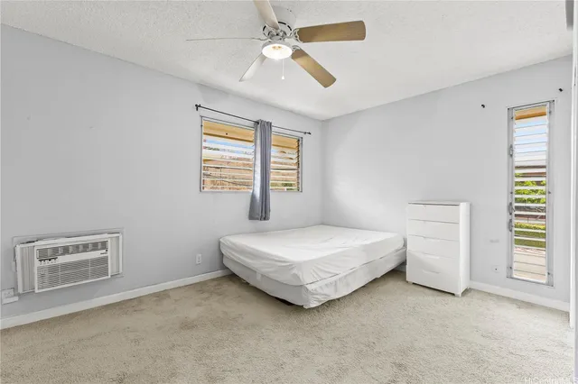 a spacious bedroom with a bed dresser and a window
