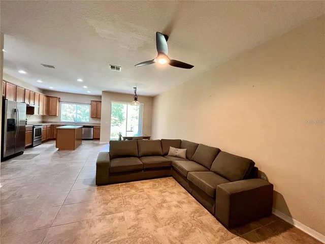 a living room with furniture and kitchen view
