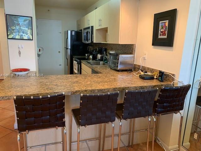 100 Lincoln Road, Unit 1129 Miami Beach, FL 33139 - Photo 5 of 31 a kitchen with a table chairs and a refrigerator