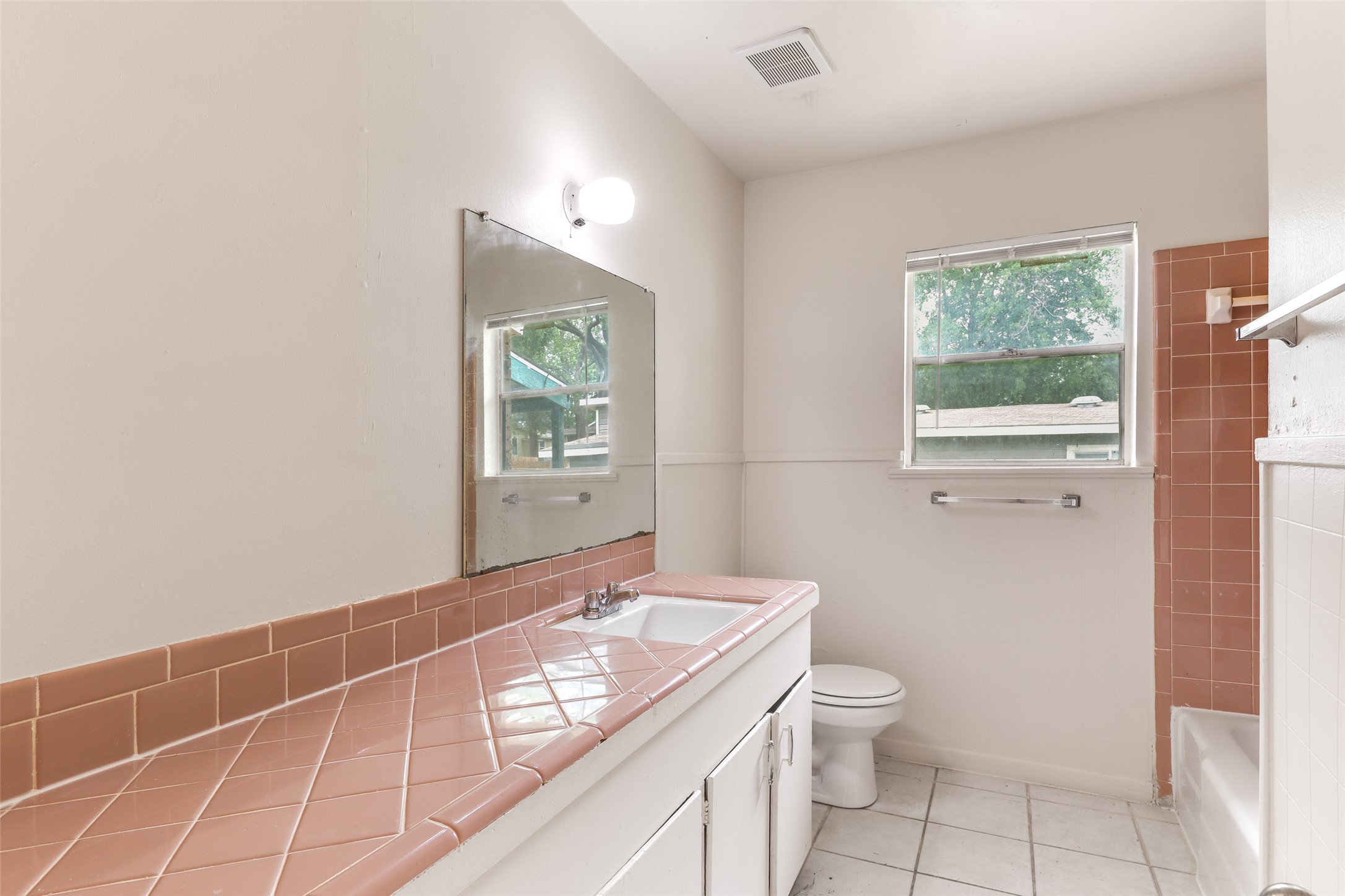 1800 Rhodes Road Austin, TX 78721 - Photo 12 of 14 a bathroom with a granite countertop sink a toilet and a mirror