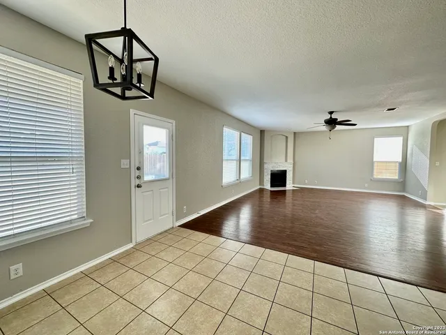 an empty room with windows and ceiling fan