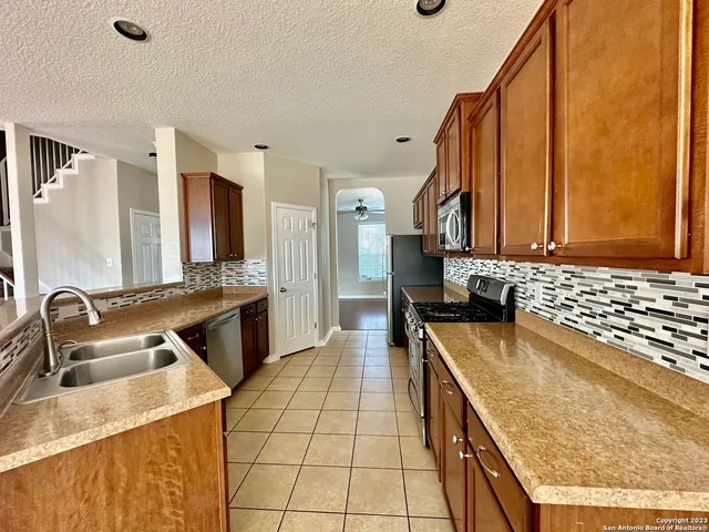 a kitchen with stainless steel appliances granite countertop a sink stove and refrigerator