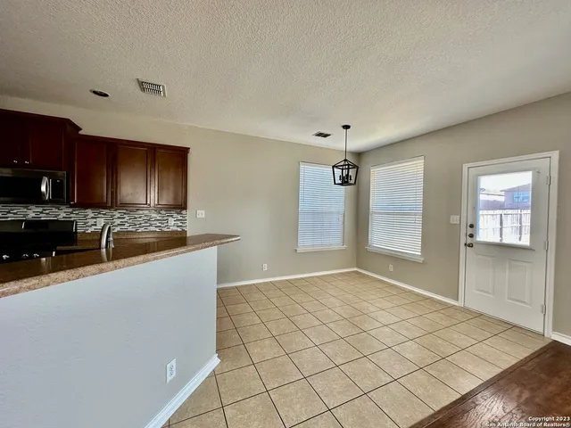 a view of a kitchen with a sink and dishwasher a refrigerator with white cabinets