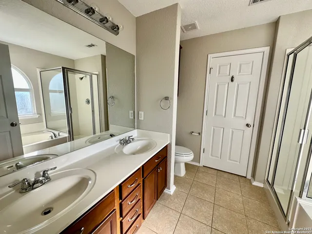 a spacious bathroom with a double vanity sink a mirror and a shower