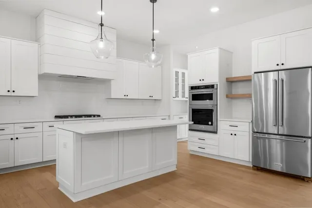 a kitchen with cabinets appliances a sink and a window