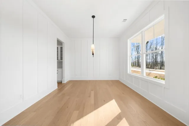 a large kitchen with stainless steel appliances kitchen island granite countertop a stove a sink a window and white cabinets