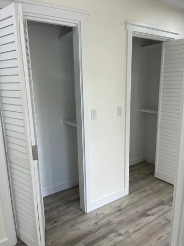 an empty room with wooden floor and closet