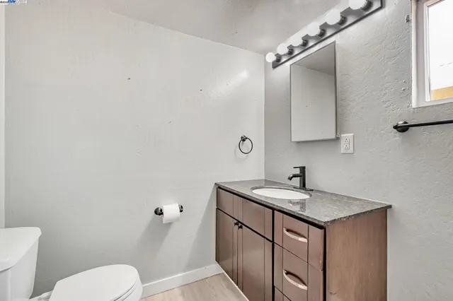 a bathroom with a toilet sink and mirror