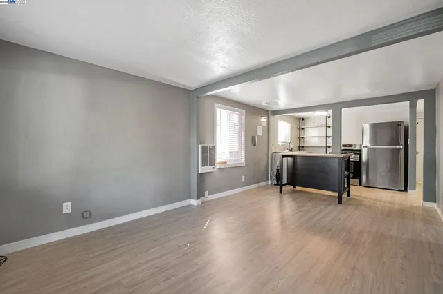 a workspace with wooden floor and a kitchen