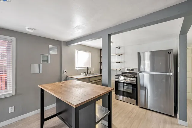 a kitchen with kitchen island a refrigerator stove microwave and sink