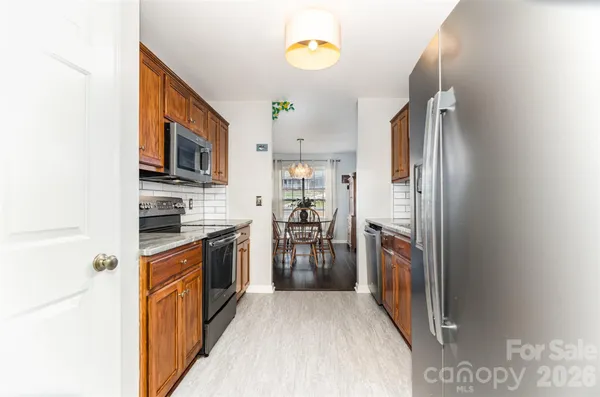 a kitchen with stainless steel appliances granite countertop a refrigerator and a stove top oven