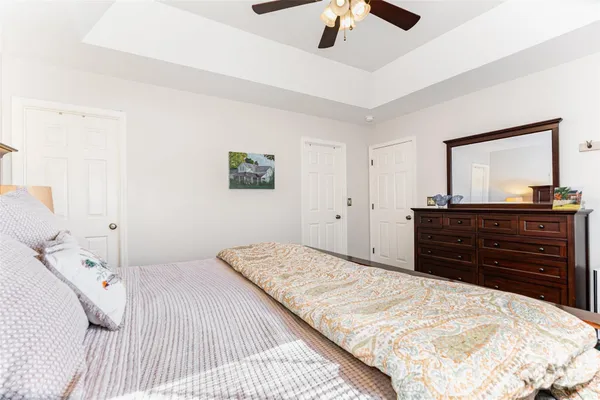 a bedroom with a bed and a mirror on dresser