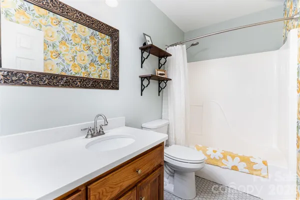 a bathroom with a sink a toilet and shower curtain