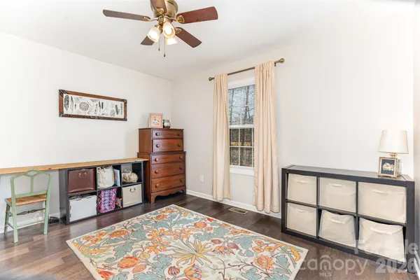 a view of a bedroom with furniture and window