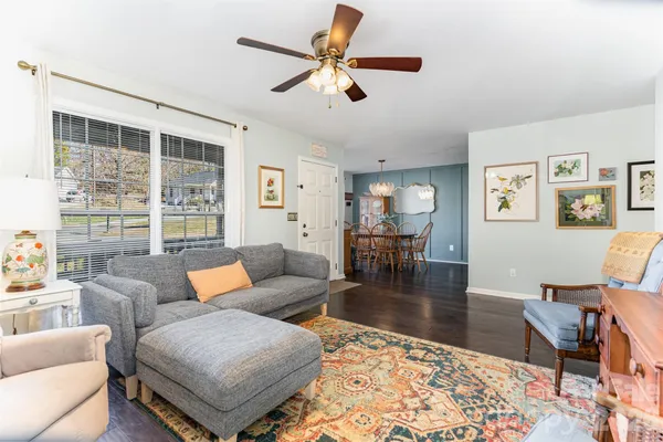 a living room with furniture wooden floor and a large window