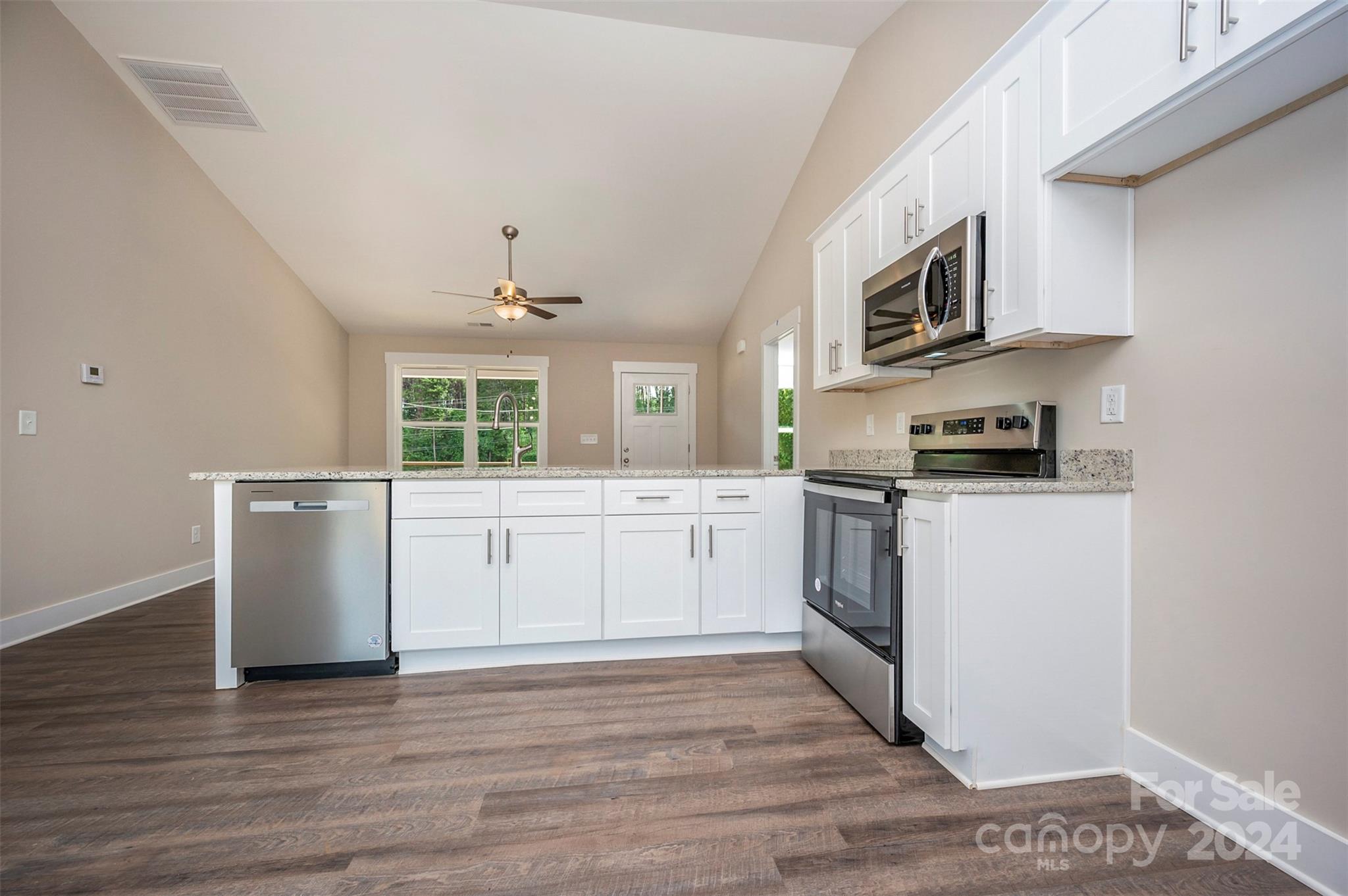 139 Forest Lake Road Forest City, NC 28043 - Photo 14 of 33 a kitchen with stainless steel appliances white cabinets and wooden floor
