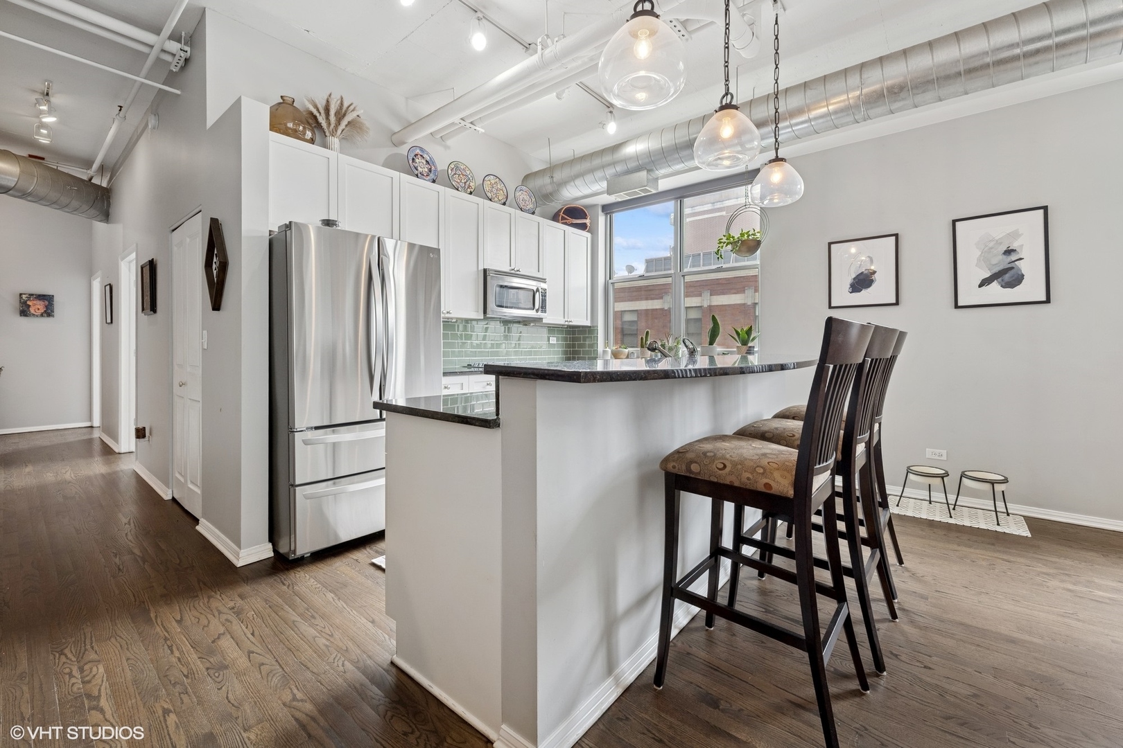 950 West Monroe Street, Unit 410 Chicago, IL 60607 - Photo 4 of 23 a kitchen with stainless steel appliances a dining table chairs and wooden floor