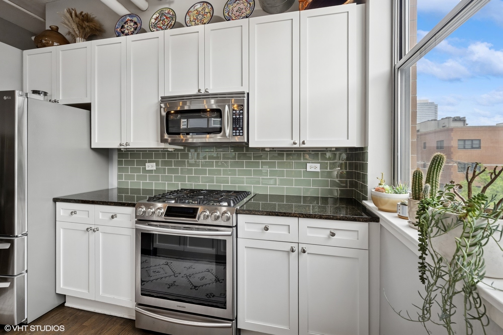 950 West Monroe Street, Unit 410 Chicago, IL 60607 - Photo 8 of 23 a kitchen with granite countertop a stove a sink and a microwave