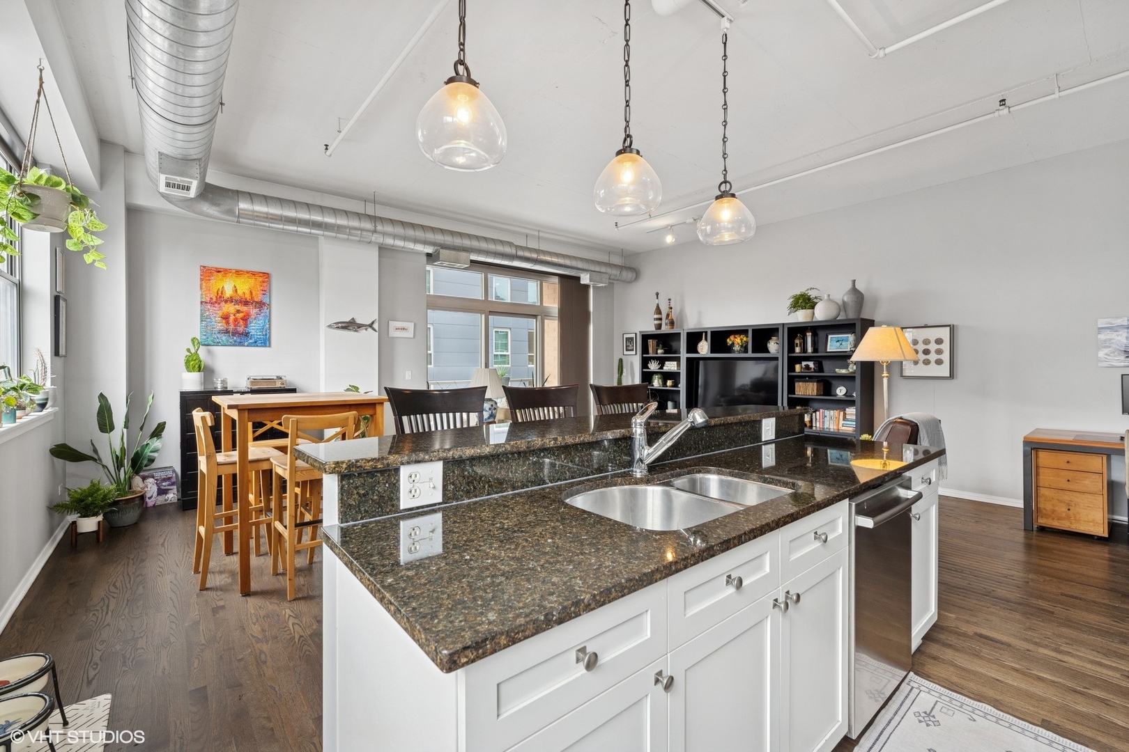 950 West Monroe Street, Unit 410 Chicago, IL 60607 - Photo 9 of 23 a kitchen with granite countertop a sink a counter space dining table and chairs