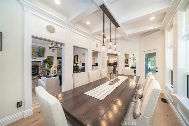 a view of a hallway with wooden floor table and chairs