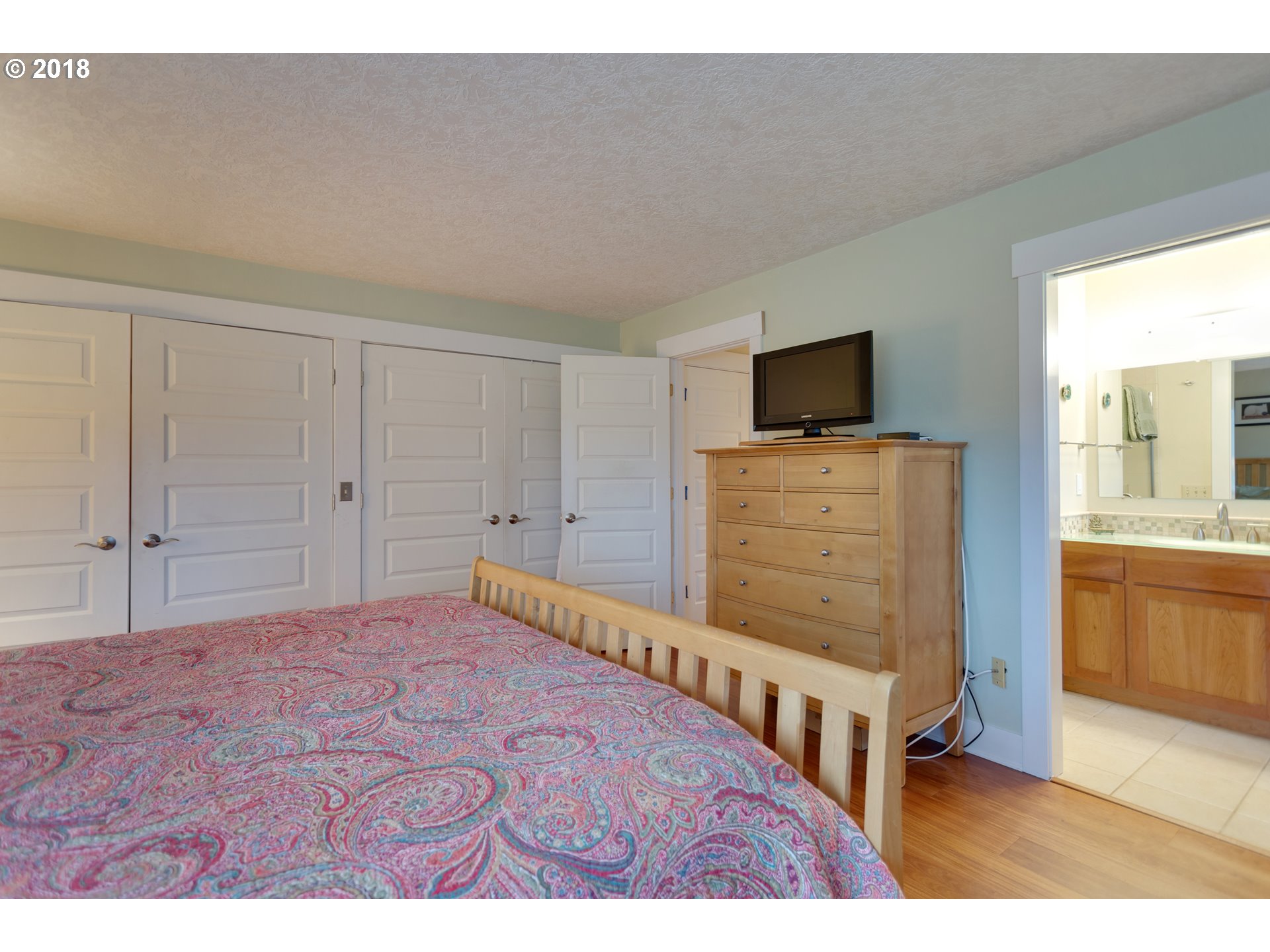 17067 South McCubbin Road Oregon City, OR 97045 - Photo 11 of 32 a bedroom with a bed and a flat tv screen on dresser