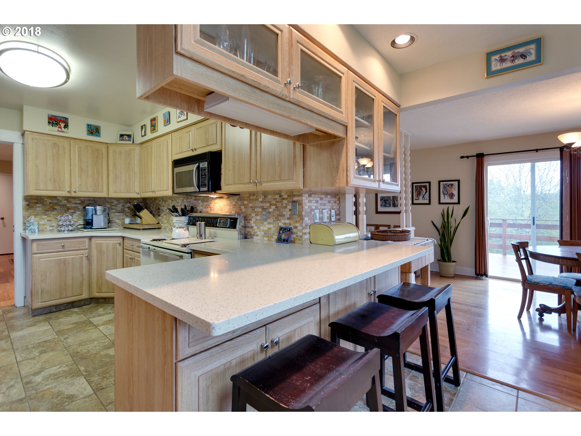 17067 South McCubbin Road Oregon City, OR 97045 - Photo 8 of 32 a kitchen with stainless steel appliances kitchen island granite countertop a table chairs and a refrigerator