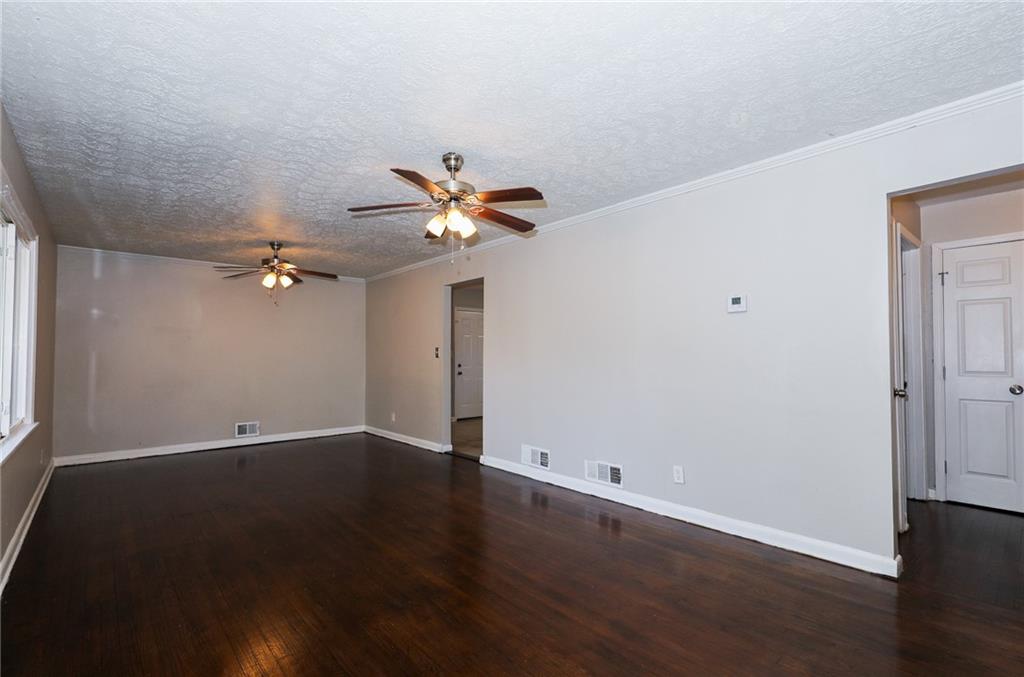 4572 Campbellton Road Southwest Atlanta, GA 30331 - Photo 5 of 21 an empty room with wooden floor and chandelier fan