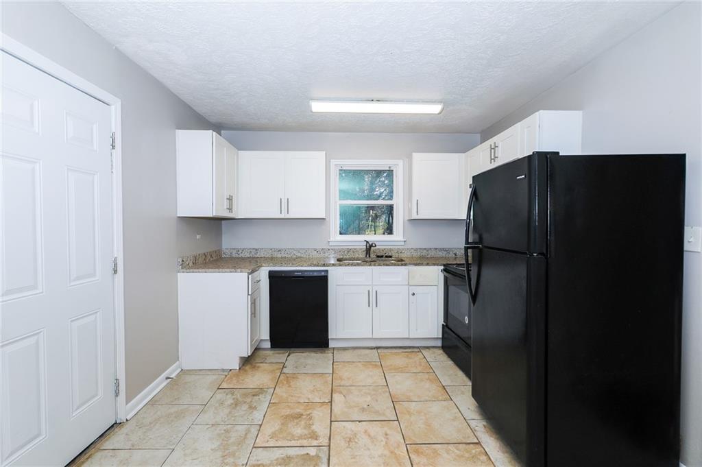 4572 Campbellton Road Southwest Atlanta, GA 30331 - Photo 9 of 21 a kitchen with a refrigerator and a sink