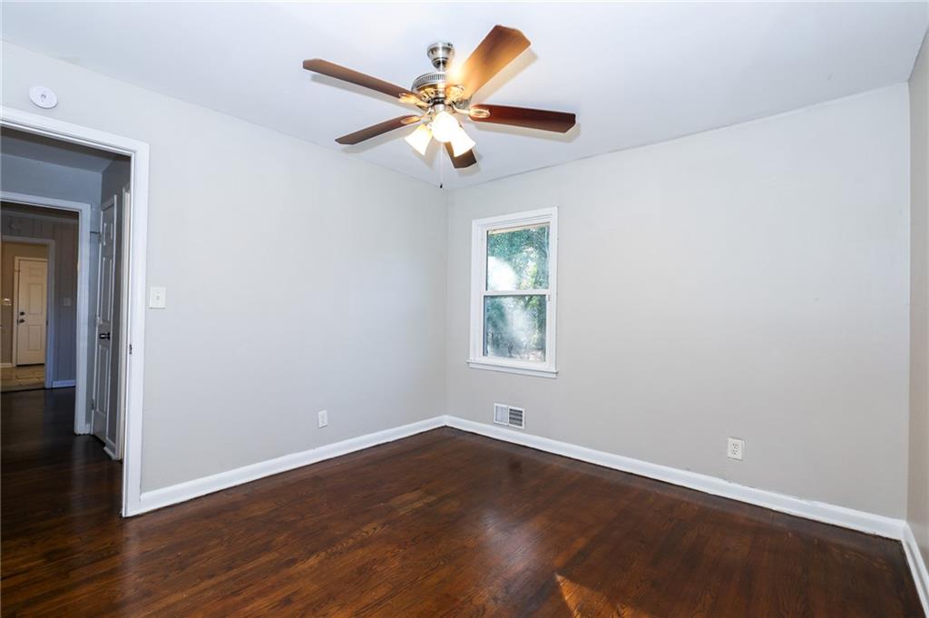 4572 Campbellton Road Southwest Atlanta, GA 30331 - Photo 10 of 21 an empty room with wooden floor fan and windows