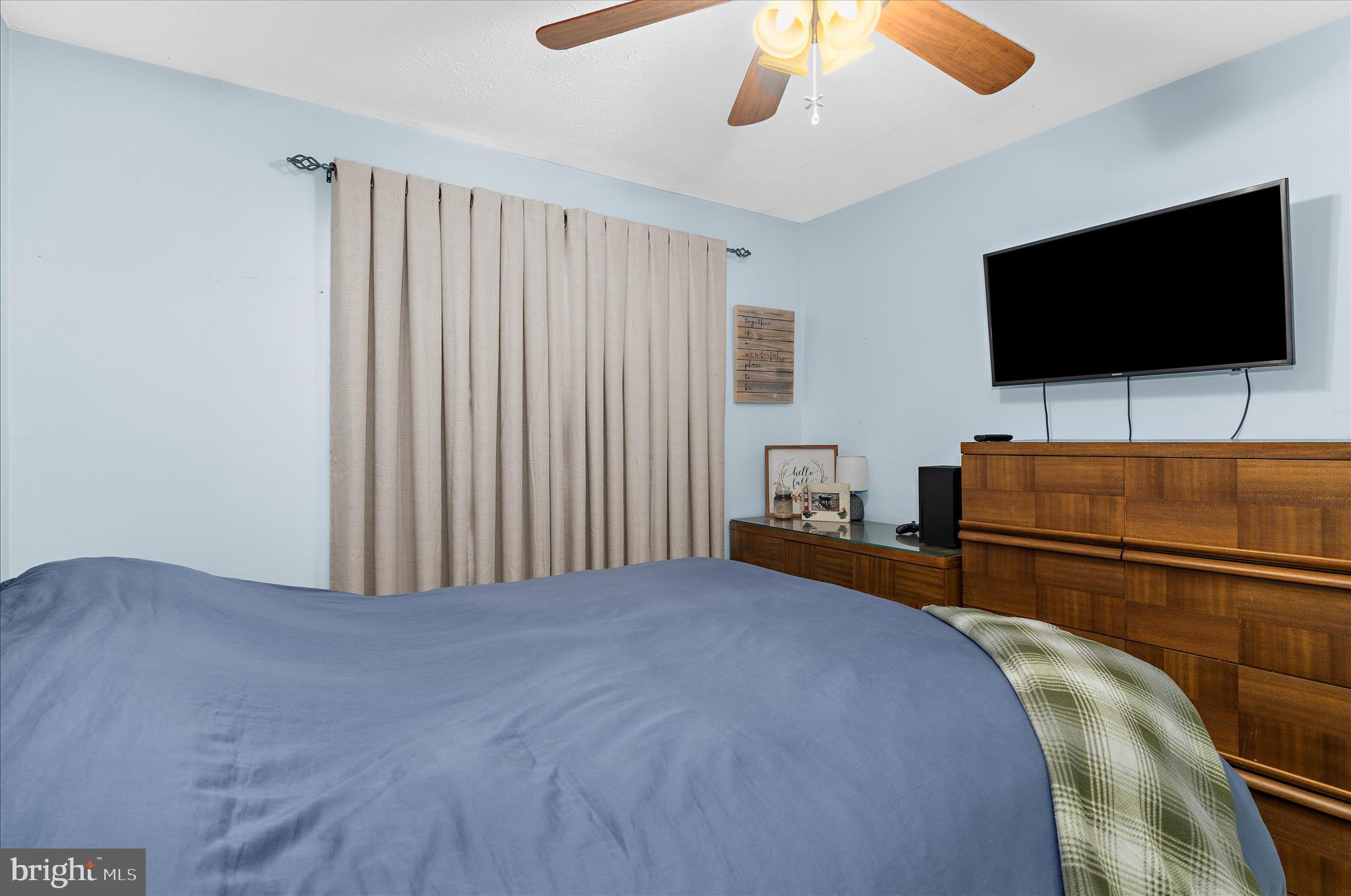 2313 230th Street Pasadena, MD 21122 - Photo 17 of 35 a bedroom with a bed and a flat screen tv