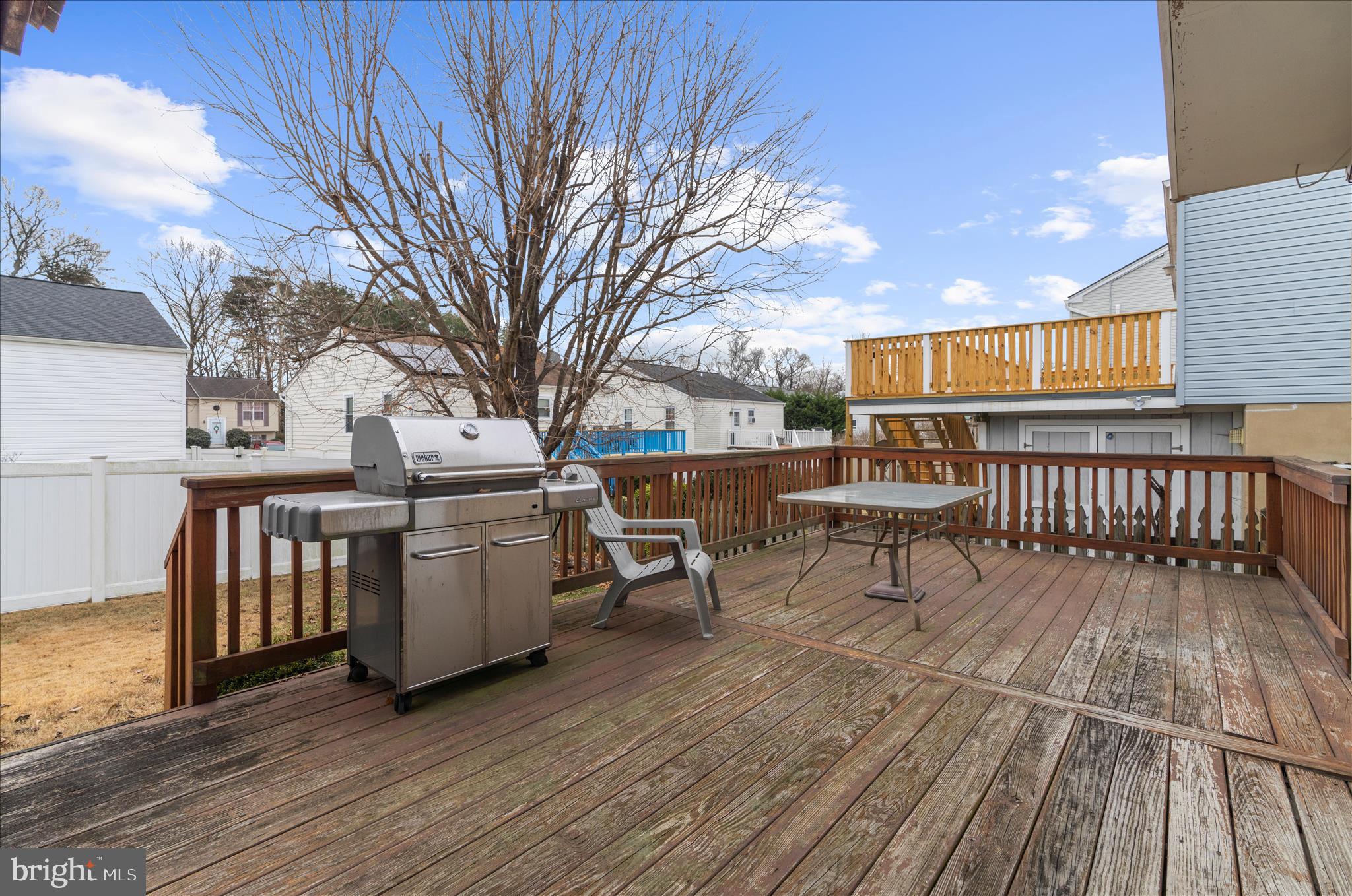 2313 230th Street Pasadena, MD 21122 - Photo 35 of 35 a view of a roof deck with table and chairs a barbeque with wooden floor and fence