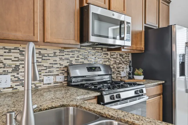 a kitchen with granite countertop a refrigerator and a stove