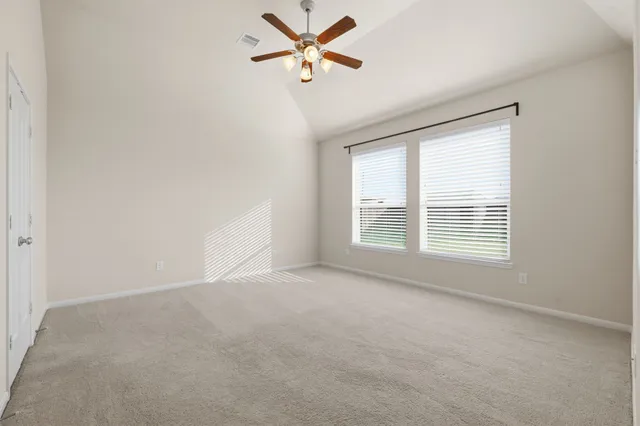 an empty room with windows and fan