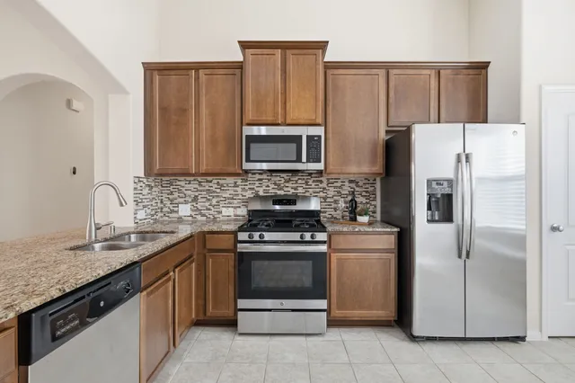 a kitchen with granite countertop a stove and a microwave