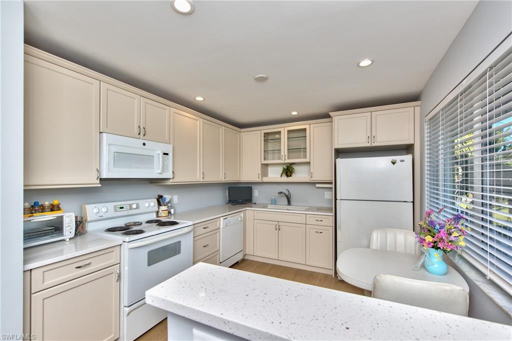 865 Teryl Road, Unit 2114 Naples, FL 34112 - Photo 11 of 26 a kitchen with white cabinets sink and white appliances