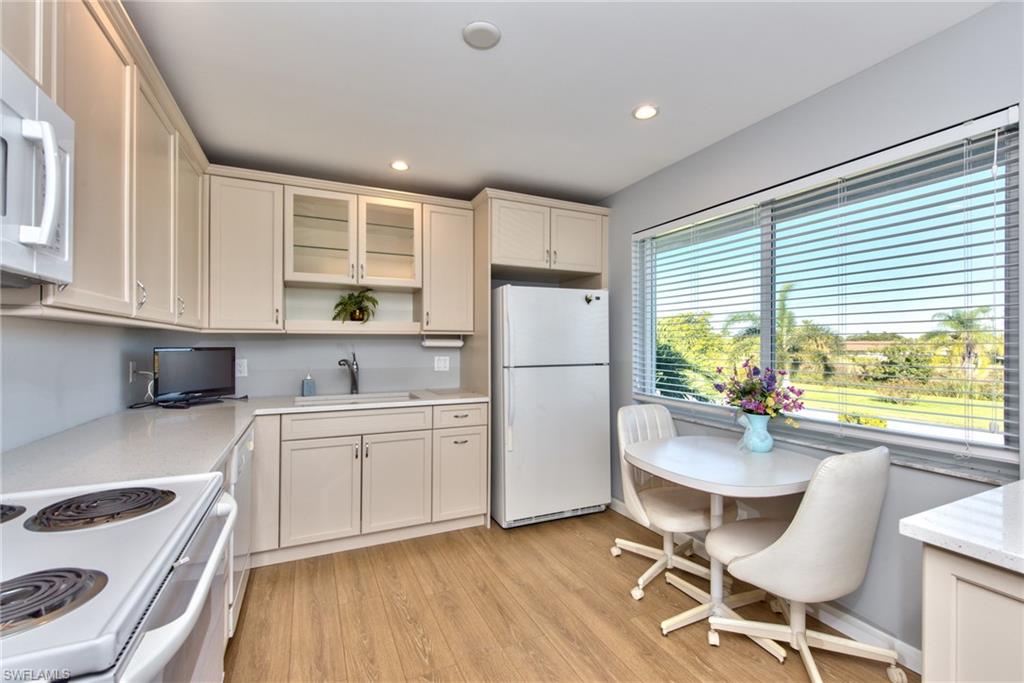865 Teryl Road, Unit 2114 Naples, FL 34112 - Photo 12 of 26 a kitchen with a dining table chairs refrigerator and cabinets