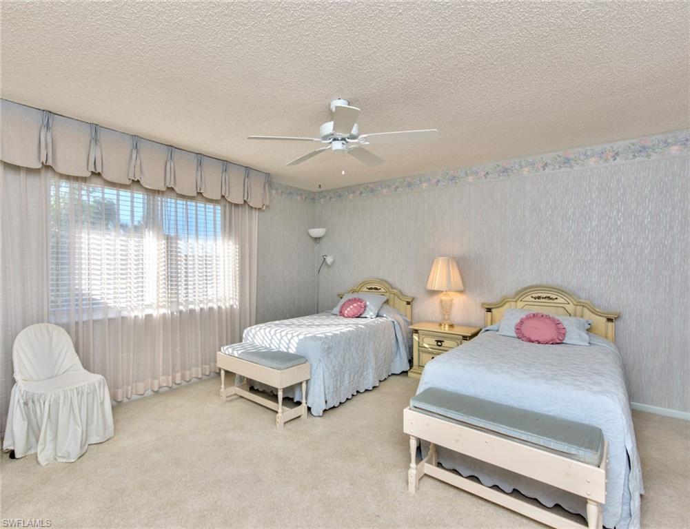 865 Teryl Road, Unit 2114 Naples, FL 34112 - Photo 13 of 26 a bedroom with two beds and a chandelier