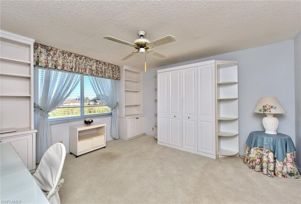 865 Teryl Road, Unit 2114 Naples, FL 34112 - Photo 16 of 26 a bedroom with a bed and a chandelier