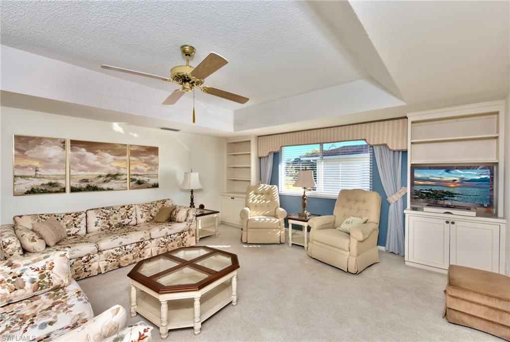 865 Teryl Road, Unit 2114 Naples, FL 34112 - Photo 5 of 26 a living room with furniture a flat screen tv and a large window