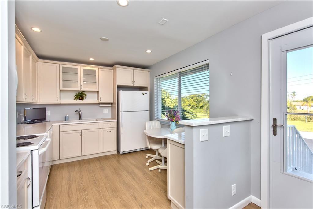 865 Teryl Road, Unit 2114 Naples, FL 34112 - Photo 10 of 26 a kitchen with a refrigerator and white cabinets