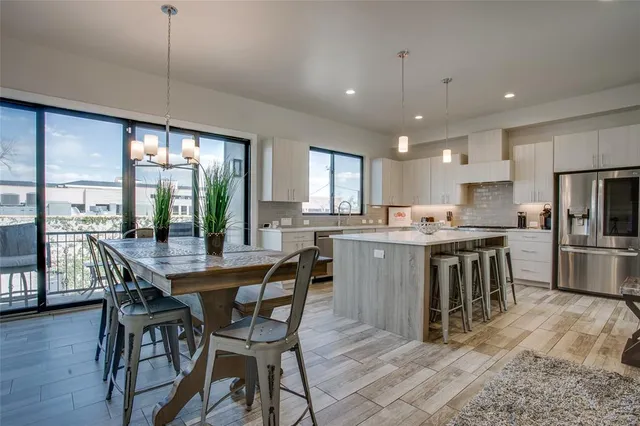 a kitchen with kitchen island a dining table chairs and wooden floor