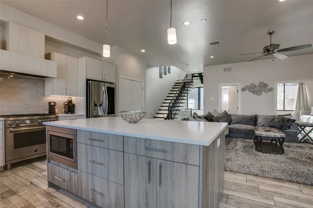 a kitchen with stainless steel appliances granite countertop a sink stove and refrigerator